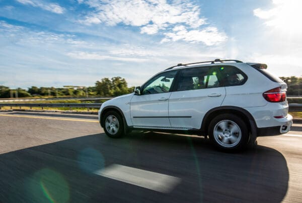 Auto Insurance in Chesterfield County, VA - White Hatchback SUV Driving on Road Sunny Day